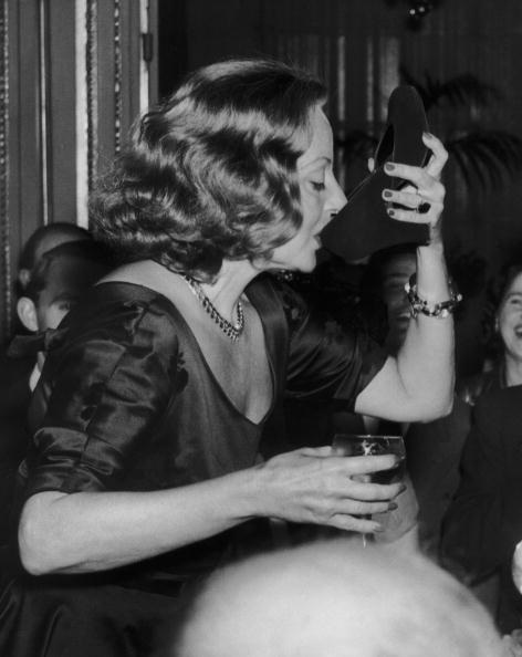 Tallula Bankhead drinking champagne out of her shoe at The Ritz 1951