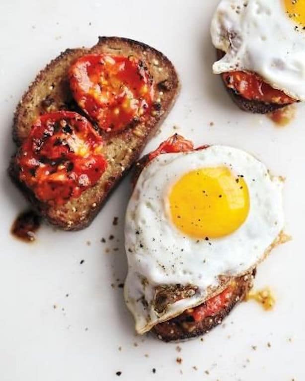 Charred tomatoes with fried eggs on garlic toast